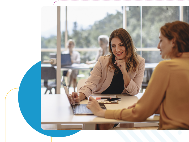 Two business women interacting with a laptop.